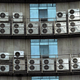 Air conditioners hang on the wall of an office building in Fuzhou, China.